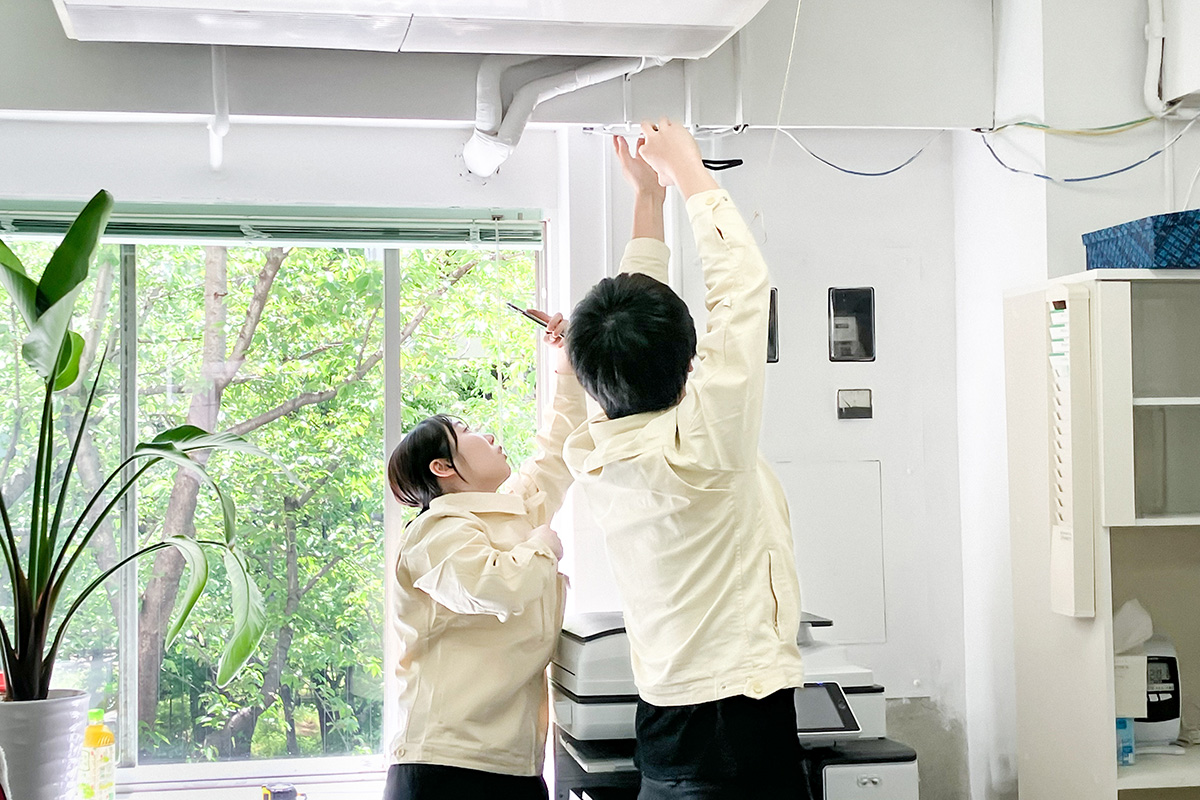 オフィス改装に向けた天井や壁の寸法を測る実測作業の様子